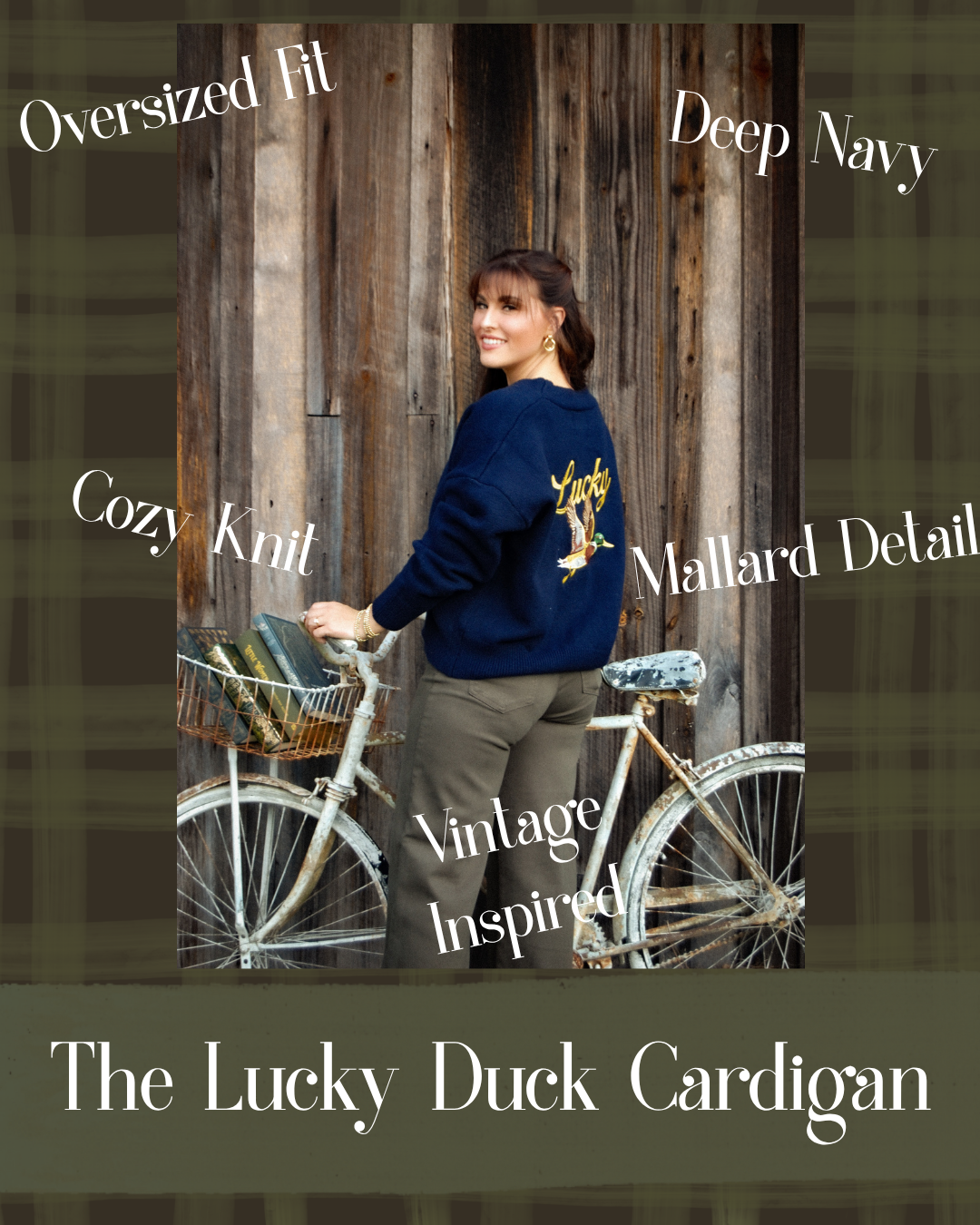 A woman wearing a navy blue cardigan with a yellow duck graphic stands next to a bicycle in front of a rustic wooden wall. The image includes text overlays describing the product features: 'Oversized Fit', 'Deep Navy', 'Cozy Knit', 'Vintage Inspired', and 'Mallard Detail'.